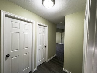 hall featuring dark wood-style floors and baseboards