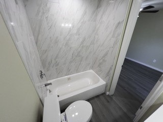 full bathroom featuring  shower combination, toilet, and wood finished floors