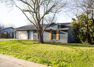 view of front facade featuring driveway, a garage, and a front lawn