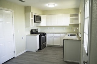 kitchen with baseboards, white cabinets, visible vents, appliances with stainless steel finishes, and a sink