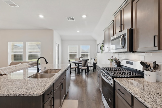 903 Saddle Club Way, Princeton, TX 75407 - kitchen featuring appliances with stainless steel finishes, an island with sink, decorative backsplash, dark wood-type flooring, and recessed lighting