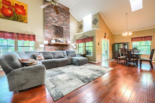 living room featuring ornamental molding, wood-type flooring, high vaulted ceiling, and ceiling fan with notable chandelier