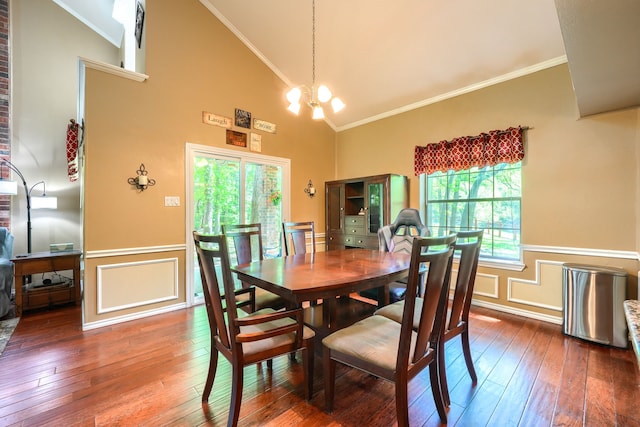 dining room featuring ornamental molding, wainscoting, high vaulted ceiling, a decorative wall, and wood-type flooring