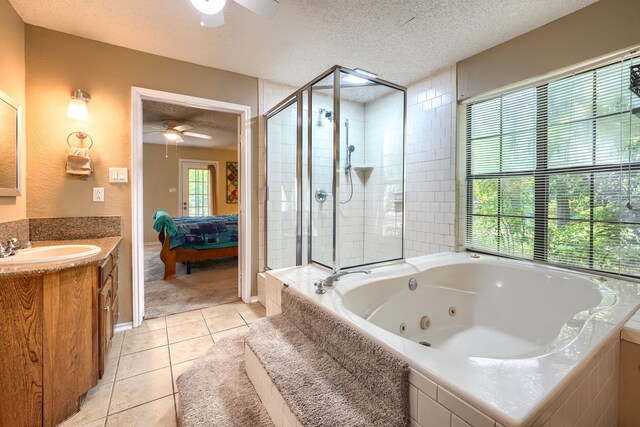 ensuite bathroom featuring a textured ceiling, ceiling fan, tile patterned flooring, and a stall shower