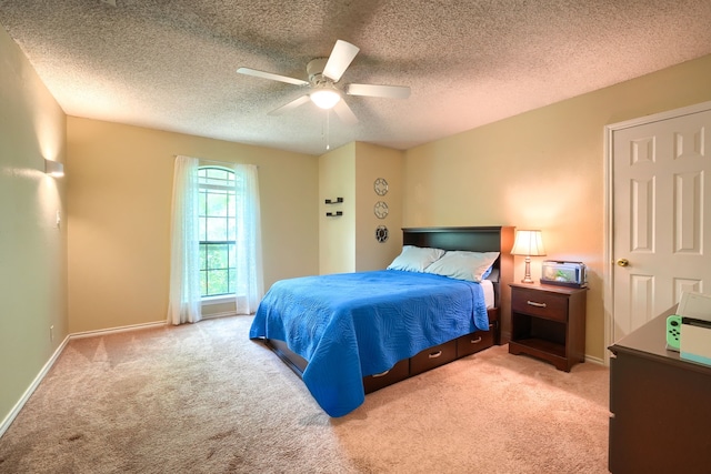 carpeted bedroom featuring a textured ceiling, ceiling fan, and baseboards