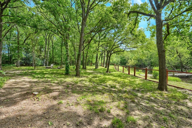 view of yard featuring a view of trees and fence