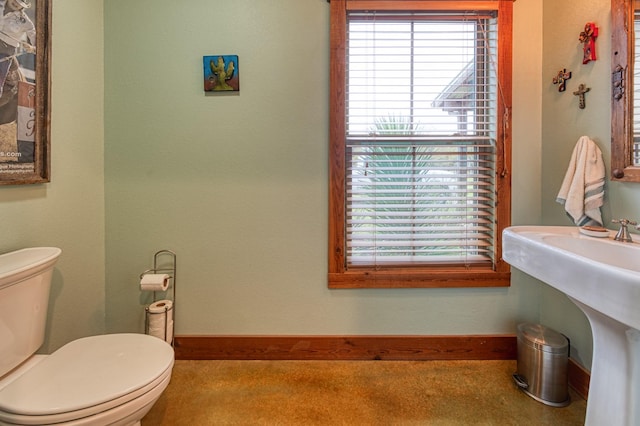 bathroom with toilet and baseboards
