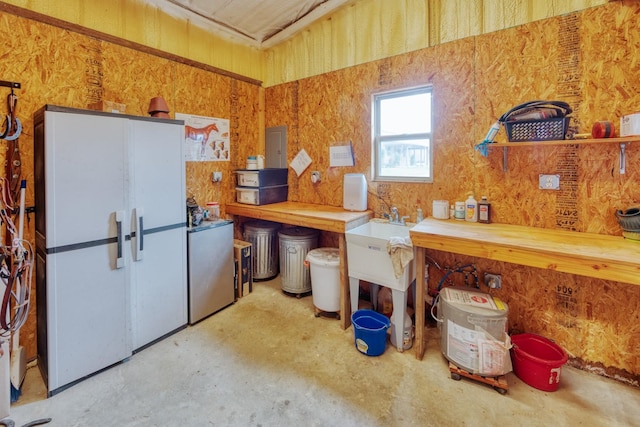 kitchen with refrigerator, freestanding refrigerator, and concrete flooring