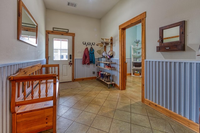 interior space featuring visible vents, a wainscoted wall, and light tile patterned floors