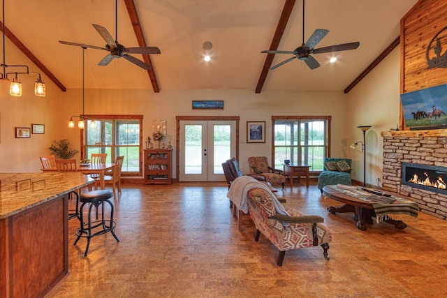 living room with high vaulted ceiling, a fireplace, a ceiling fan, and beam ceiling