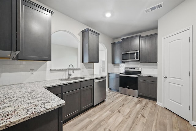 202 Lake Rdg, Princeton, TX 75407 - kitchen featuring arched walkways, visible vents, appliances with stainless steel finishes, a sink, and light wood finished floors