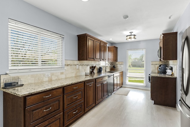 2113 Victoria Rd, Carrollton, TX 75007 - kitchen with decorative backsplash, a sink, stainless steel appliances, and light wood-style floors