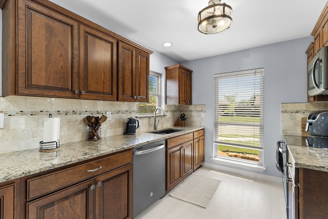 2113 Victoria Rd, Carrollton, TX 75007 - kitchen with a sink, baseboards, backsplash, light stone counters, and appliances with stainless steel finishes
