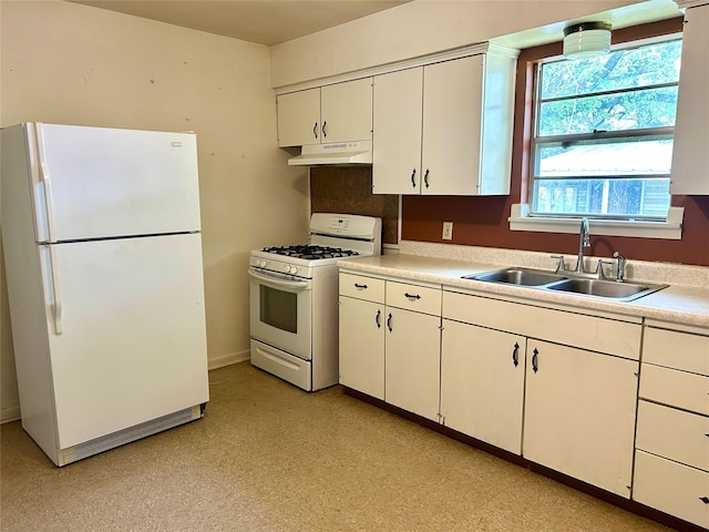kitchen with white appliances, light countertops, white cabinetry, under cabinet range hood, and a sink