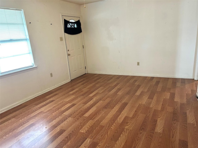 empty room featuring wood finished floors and baseboards