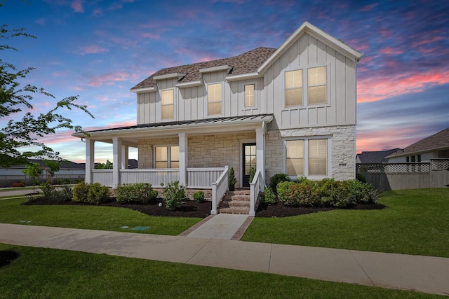 1304 S Pecan Pkwy, Northlake, TX 76247 - view of front facade featuring covered porch, board and batten siding, a standing seam roof, a front lawn, and stone siding