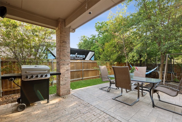 view of patio featuring a fenced backyard, outdoor dining space, and a grill