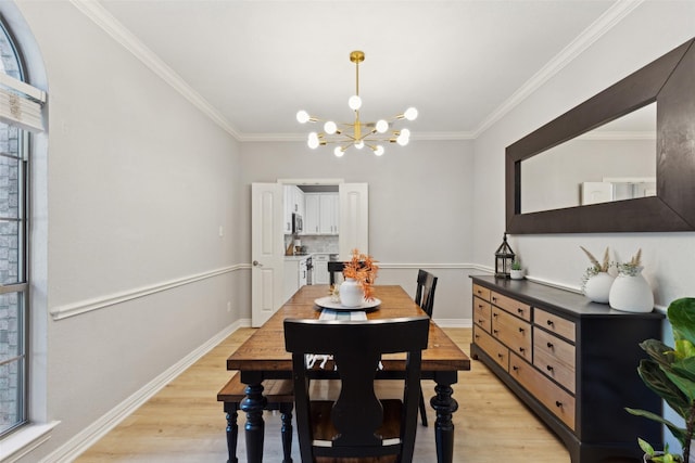 dining room with ornamental molding, light wood-style flooring, and a chandelier