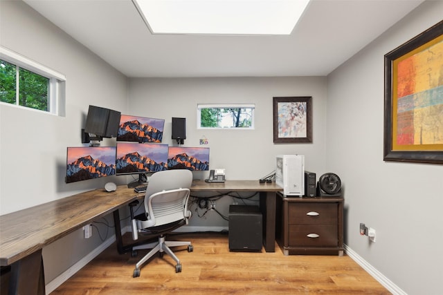 office area with light wood-style floors and baseboards