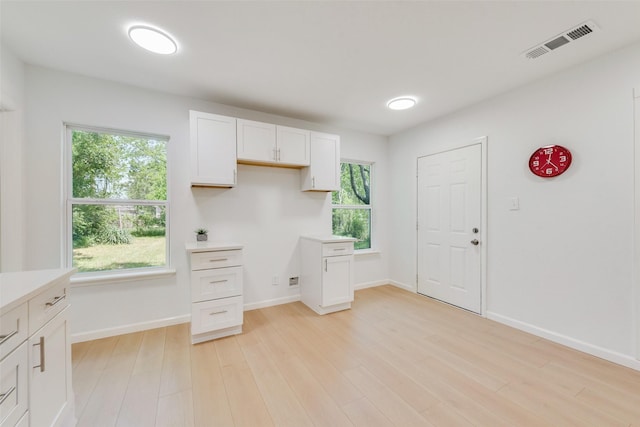 5816 Kilpatrick Ave, Fort Worth, TX 76107 - kitchen with light wood finished floors, white cabinets, healthy amount of natural light, and light countertops