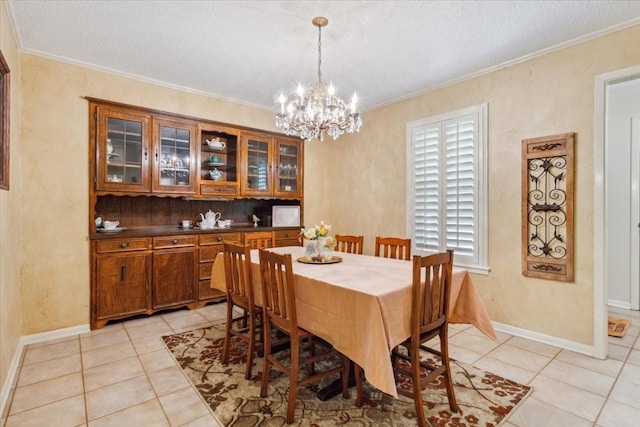dining room with a chandelier, light tile patterned floors, and baseboards
