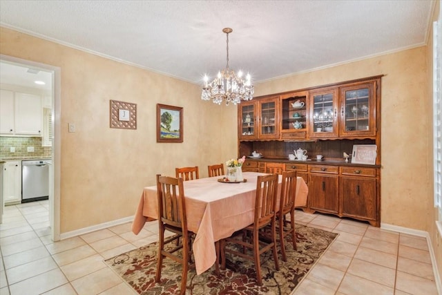 dining space with a notable chandelier, baseboards, crown molding, and light tile patterned flooring
