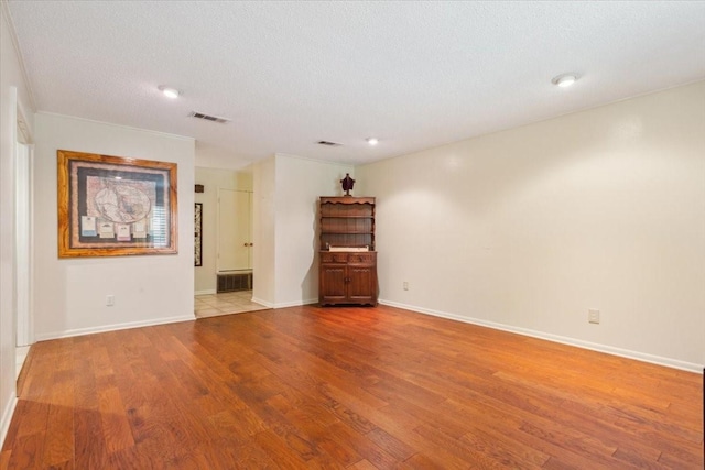 unfurnished room with visible vents and wood finished floors