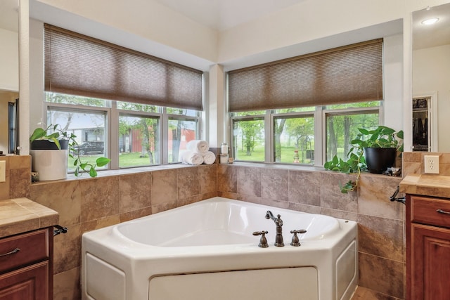 bathroom with tile walls, a bath, and vanity