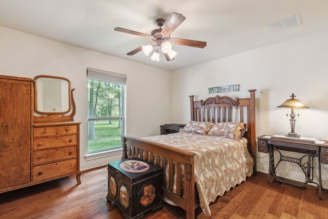 bedroom featuring wood finished floors, baseboards, a ceiling fan, and visible vents