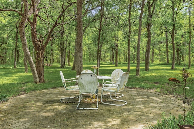 view of yard with a view of trees and a patio