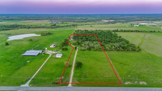 aerial view at dusk featuring a rural view