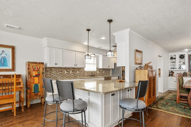 kitchen with a textured ceiling, dark wood finished floors, and a breakfast bar