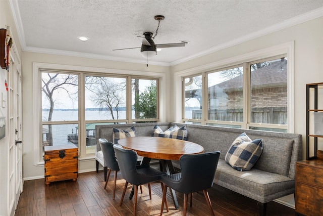 dining room with breakfast area, dark wood-style floors, a ceiling fan, and crown molding