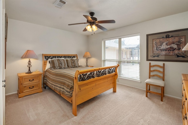 bedroom with visible vents, baseboards, ceiling fan, and light carpet