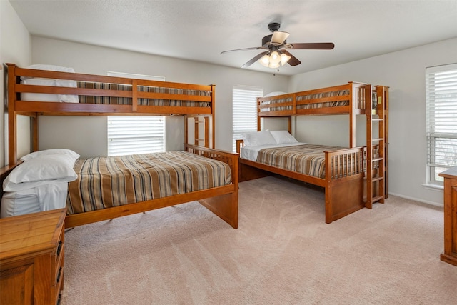 bedroom featuring baseboards, a ceiling fan, and light colored carpet