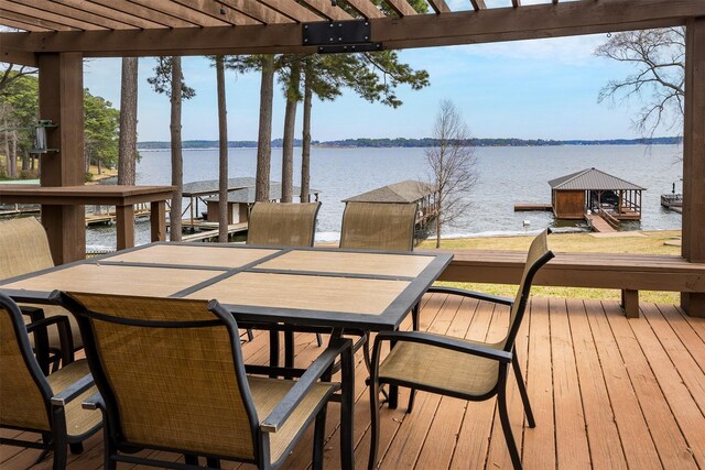 deck with a dock, a pergola, outdoor dining area, and a water view