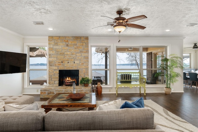 living room with crown molding, visible vents, ceiling fan, and hardwood / wood-style flooring