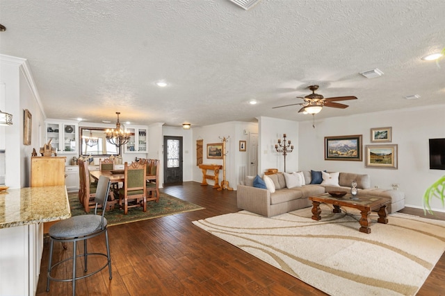 living room featuring dark wood-type flooring, visible vents, baseboards, and a textured ceiling