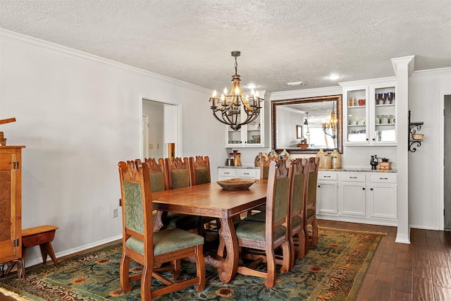 dining area featuring an inviting chandelier, dark wood-style flooring, a textured ceiling, and crown molding