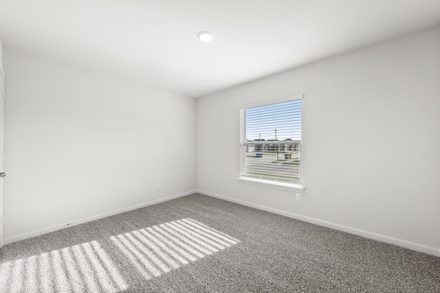 unfurnished room featuring carpet floors and baseboards