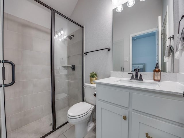 bathroom with vanity, a stall shower, and toilet