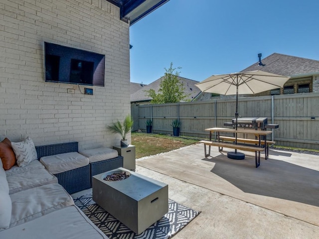 view of patio / terrace with a fenced backyard and an outdoor living space with a fire pit