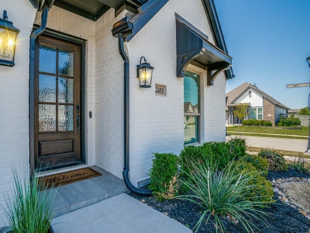 property entrance featuring brick siding