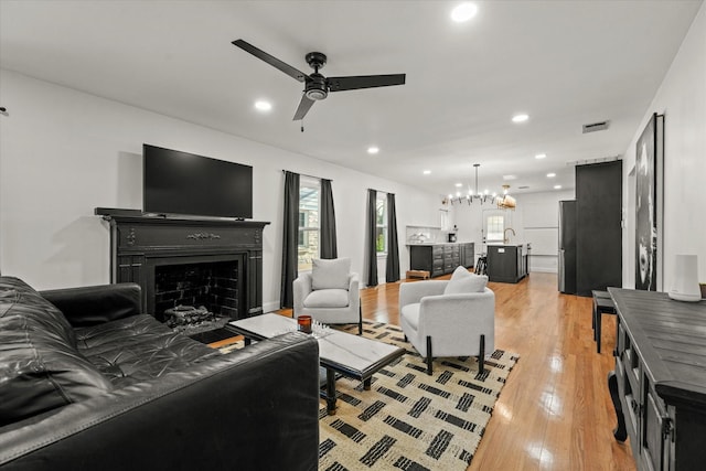 1622 Hollywood Ave, Dallas, TX 75208 - living area with light wood-style flooring, visible vents, recessed lighting, a fireplace, and ceiling fan with notable chandelier