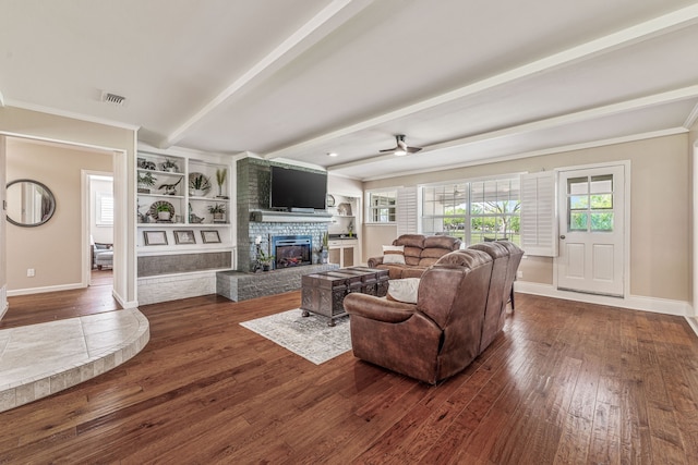 living area with baseboards, a stone fireplace, ceiling fan, dark wood-style floors, and beam ceiling