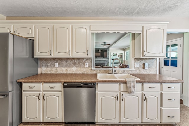 kitchen featuring a sink, cream cabinetry, tasteful backsplash, and appliances with stainless steel finishes