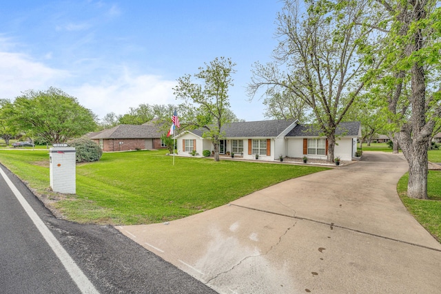 ranch-style home with roof with shingles, driveway, stucco siding, and a front lawn