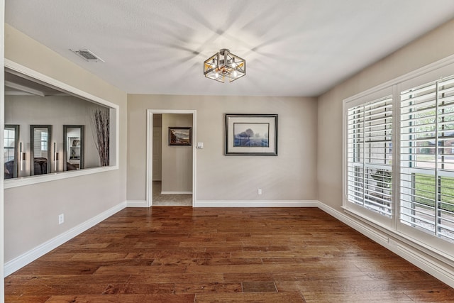 unfurnished dining area featuring visible vents, baseboards, and dark wood-style floors