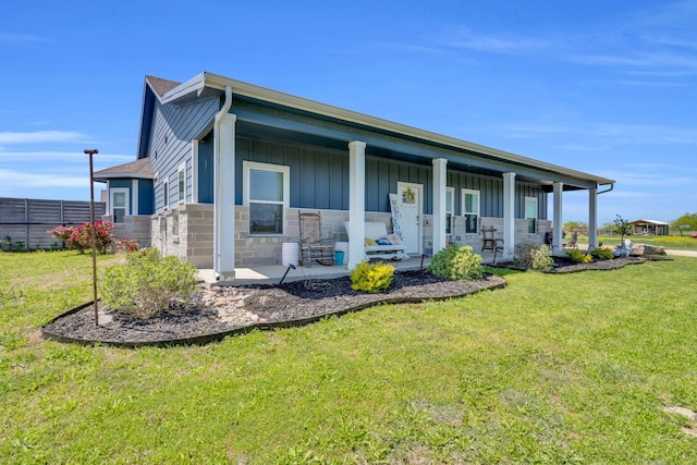 view of front of home with board and batten siding, stone siding, and a front lawn