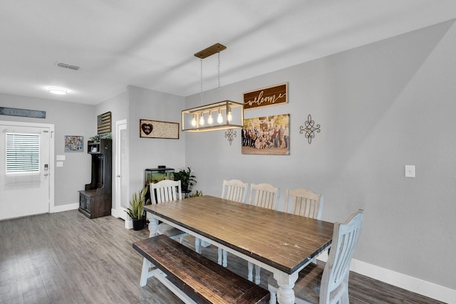 dining space with wood finished floors, baseboards, and visible vents